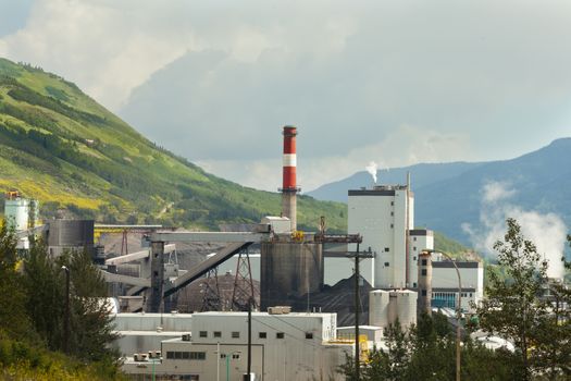 Black coal mine pile at coal fired electric energy power station in green valley contributes to global warming