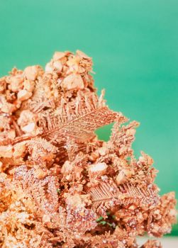 Native copper crystalline metal mineral rock against neutral green background