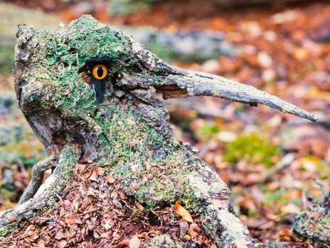 Scary forest fantasy long nose chimera with sparkling orange eye and lichens cover