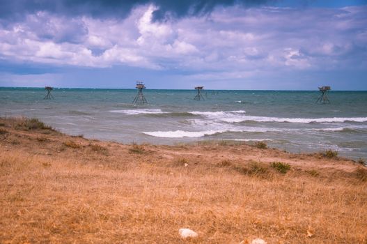 Seascape with fishing rigs. Stormy sky. West coast of Crimea.