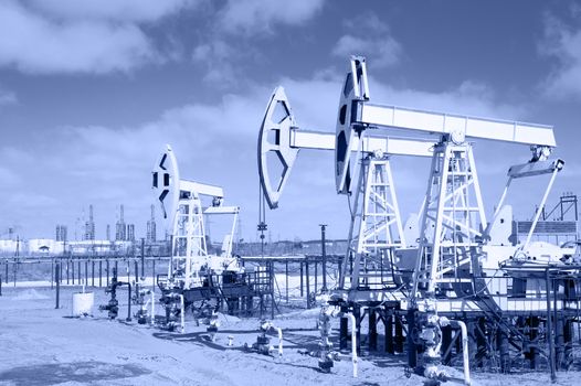 Pump jack group and wellheads. Extraction of oil. Toned.