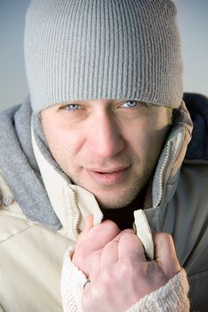 Man in warm gray jacket and hat. Close up.
