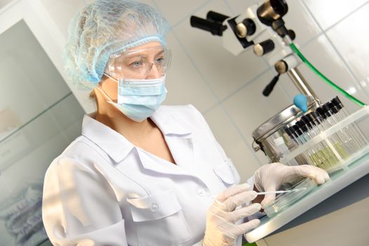 A female doctor examines a sample. 
Could be useful for medicine, hospital, research and development, clinical studies, forensics, science etc