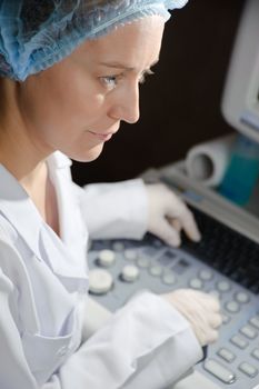 Female doctor in a white uniform working wiht scientific equipment.