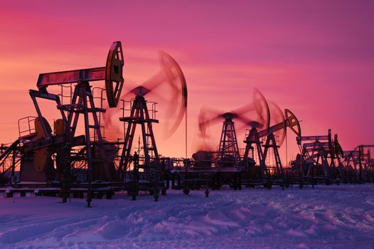 Oil and gas industry. Pump jacks at sunset sky background.
