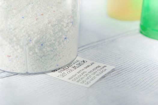 Close up view on an washing label tag and washing powder .