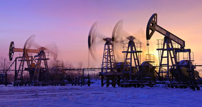 oil pumps at sunset sky background. panorama.