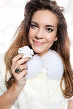 Brunette fashion model in white fur posing on a white background