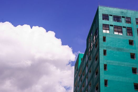 green tall building on blue sky background