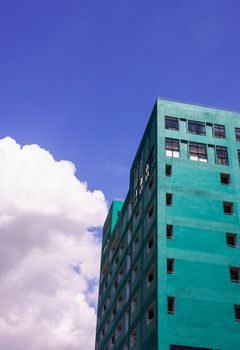 green tall building on blue sky background