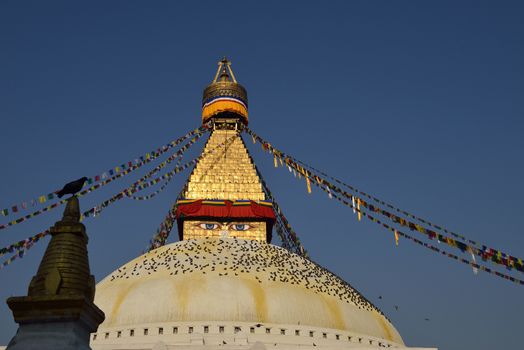 Buddhist Shrine Boudhanath Stupa with pray flags over blue sky. Nepal, Kathmandu