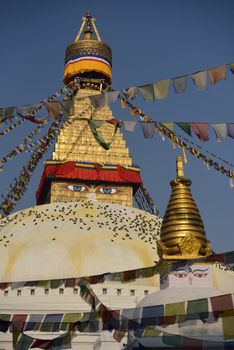 Buddhist Shrine Boudhanath Stupa with pray flags over blue sky. Nepal, Kathmandu