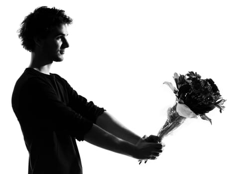 young man offering flowers bouquet silhouette in studio isolated on white background