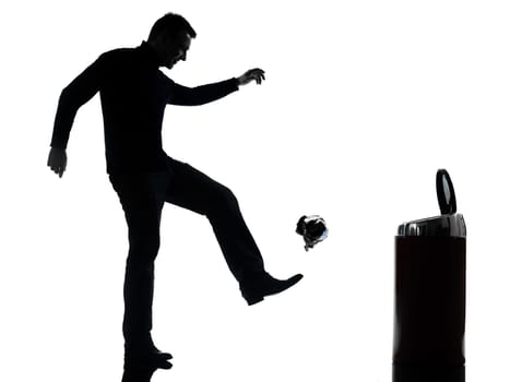 one caucasian man dropping a paper in a trash bin full length in silhouette studio isolated on white background