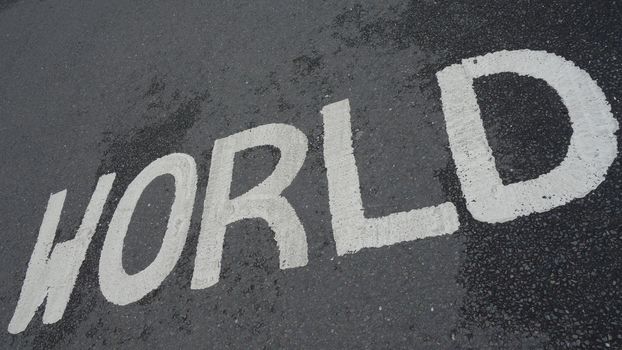 World sign written in white paint on tarmac