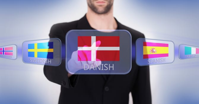 Hand pushing on a touch screen interface, choosing language or country, Denmark