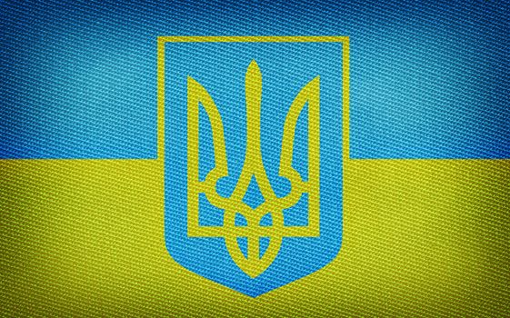 Grunge Ukrainian flag with trident on fabric backround