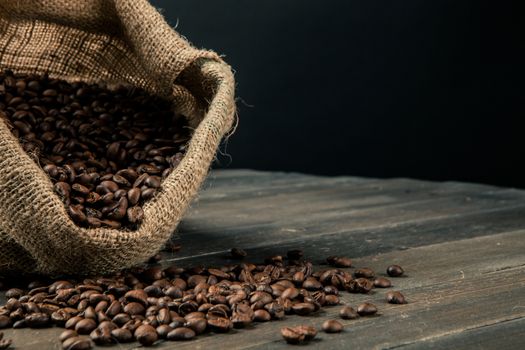 sack made by jute full of coffee beans,scattered on a wooden table