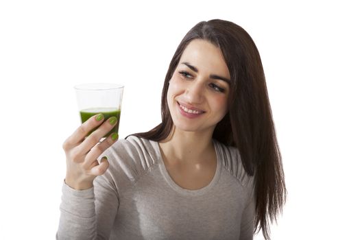 Beautiful smiling brunette holding a glass with green juice isolated on white background. Healthy lifestyle, alternative medicine, weight loss and detox.