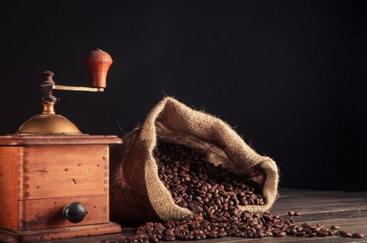 jute bag full of coffee beans and old grinder