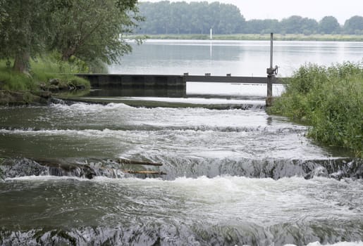 waterfall in holland from the river maas with green nature 
