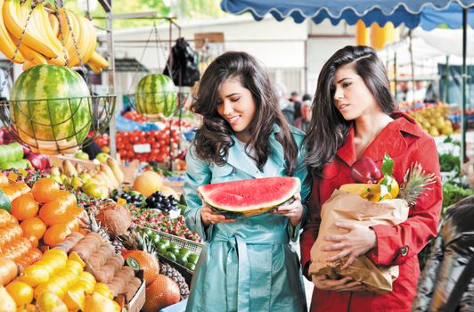 sisters shopping fruits at an outdoors farmers market
