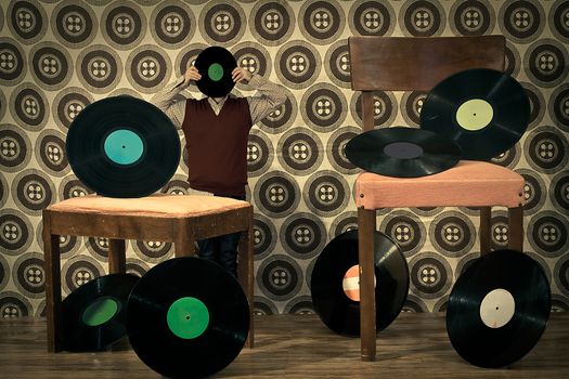 retro room full with 33rpm discs on chair, a little man with a lp face is behind a footrest