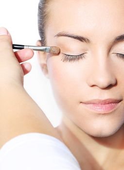 woman places a shadow on the eyelid brush