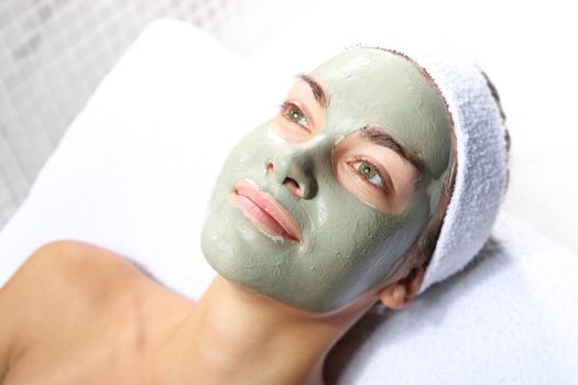 beautiful joyful woman in the mask with green clay