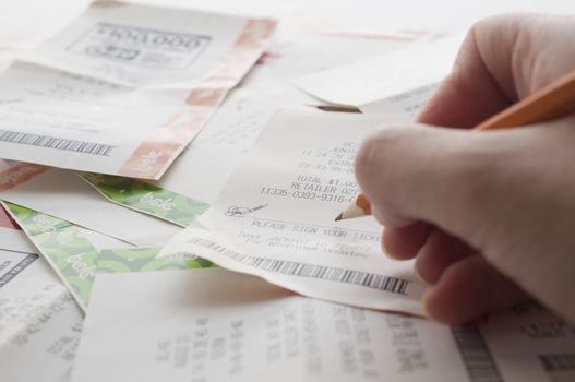 Coquitlam BC Canada - May 31, 2014 : Woman prepare to sign a lottery ticket. The British Columbia Lottery Corporation has  provided government sanctioned lottery games in British Columbia since 1985. 