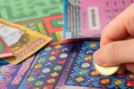 Coquitlam BC Canada - May 25, 2014 : Scratching lottery tickets. The British Columbia Lottery Corporation has provided government sanctioned lottery games in British Columbia since 1985. 