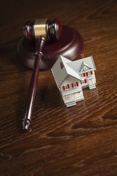 Gavel and Small Model House on Wooden Table.