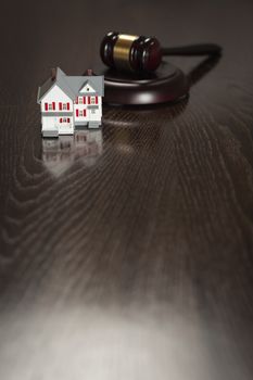 Gavel and Small Model House on Wooden Table.