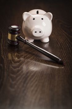 Gavel and Piggy Bank on Wooden Table.