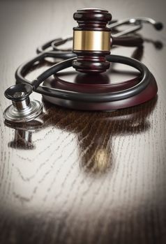 Gavel and Stethoscope on Reflective Wooden Table.