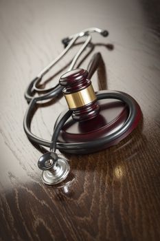 Gavel and Stethoscope on Reflective Wooden Table.