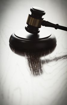 Dramatic Gavel Silhouette on Reflective Wood Surface.