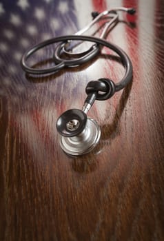 Knotted Stethoscope with American Flag Reflection on Wooden Table.