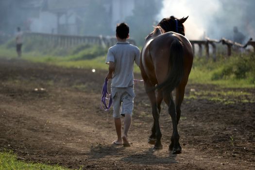 bandung, indonesia-may 31, 2014-man get walking together with his horse in arcamanik horse race arena