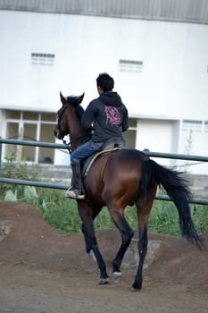 bandung, indonesia-may 31, 2014-young boy learn to riding a horse in arcamanik horse race arena