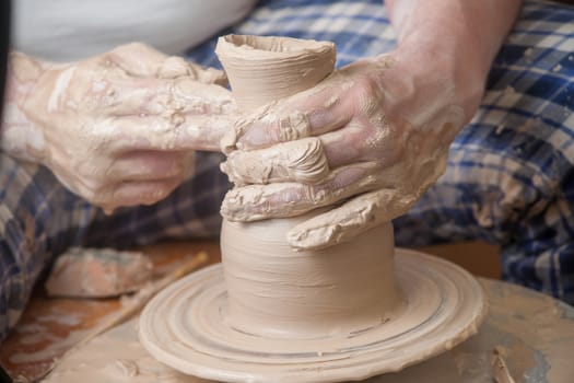 Hands of a potter, creating an earthen jar on the circle