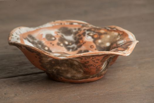 Traditional handcrafted dish of brown color on the table