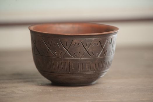Traditional handcrafted dish of brown color on the table