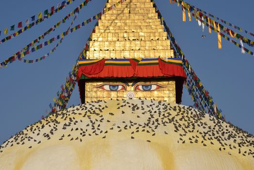 Buddhist Shrine Boudhanath Stupa with pray flags over blue sky. Nepal, Kathmandu