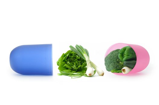 Miniature green vegetables inside an open capsule pill 