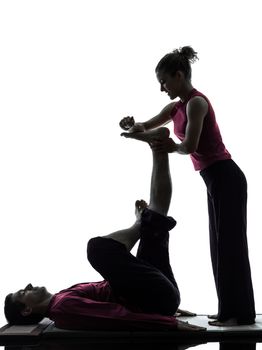 one man and woman performing feet legs thai massage in silhouette studio on white background