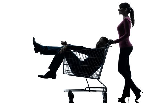 one caucasian couple woman with man sitting in shopping cart  in silhouette studio isolated on white background
