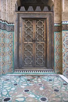 Ornate carving on the plastered walls and on the woodwork in the courtyard of the historic Madrasa Bou Inania in the ancient medina of Fes in Morocco