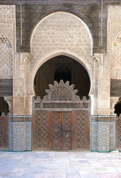 Ornate carving on the plastered walls and on the woodwork in the courtyard of the historic Madrasa Bou Inania in the ancient medina of Fes in Morocco