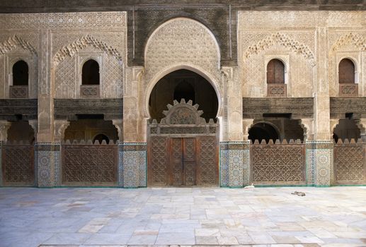 Ornate carving on the plastered walls and on the woodwork in the courtyard of the historic Madrasa Bou Inania in the ancient medina of Fes in Morocco